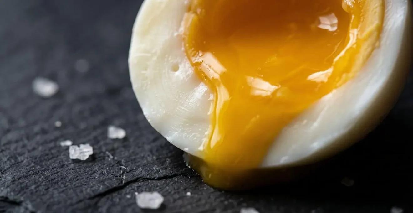 Gros plan macro sur un œuf parfait à 63°C montrant la texture crémeuse du blanc et du jaune coulant
