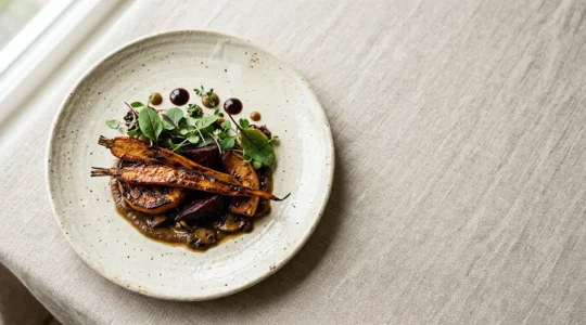 Assiette gastronomique végétale aux textures et couleurs complexes présentée avec art
